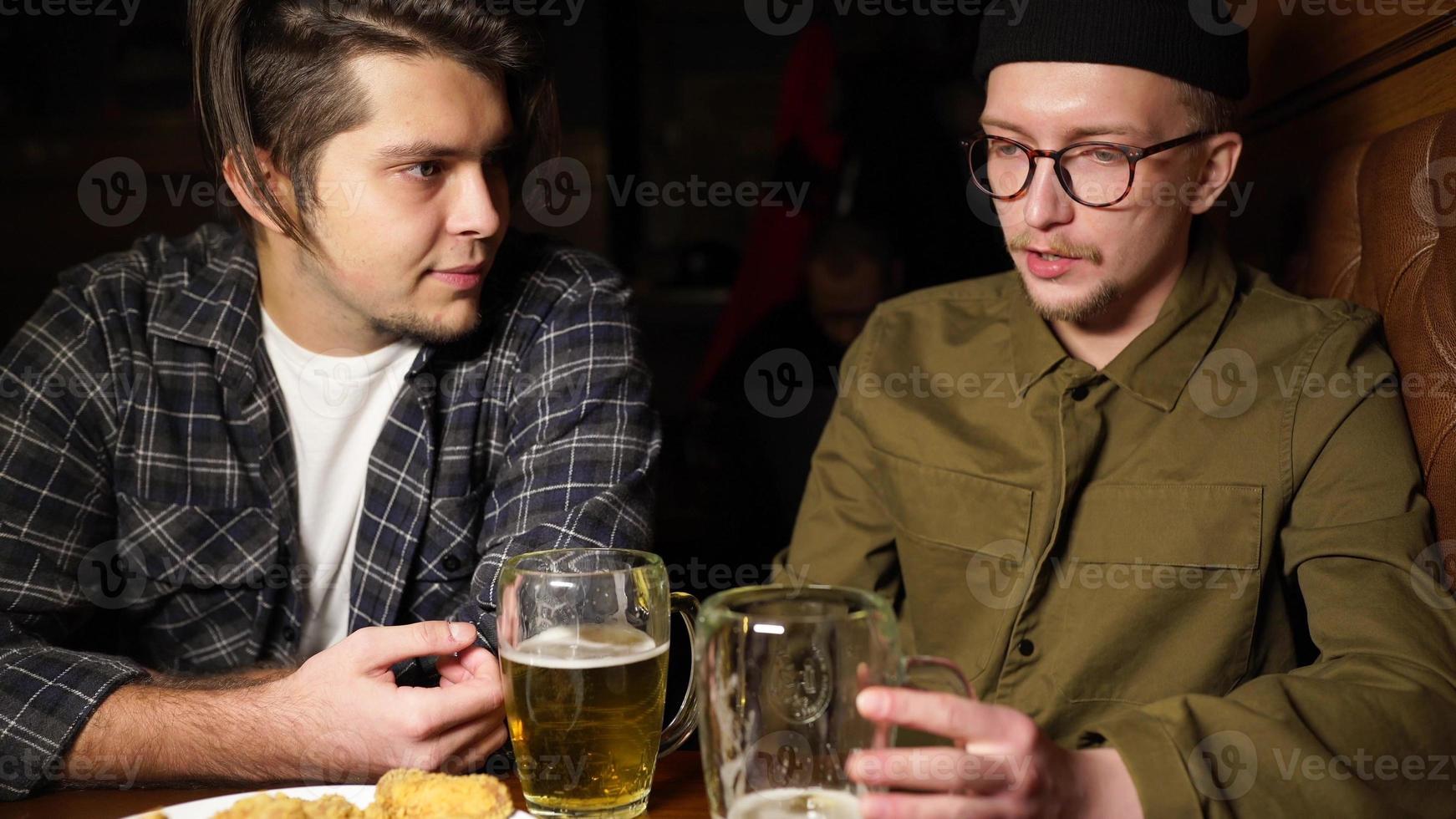 Young friends having fun together drinking beer in a pub. photo