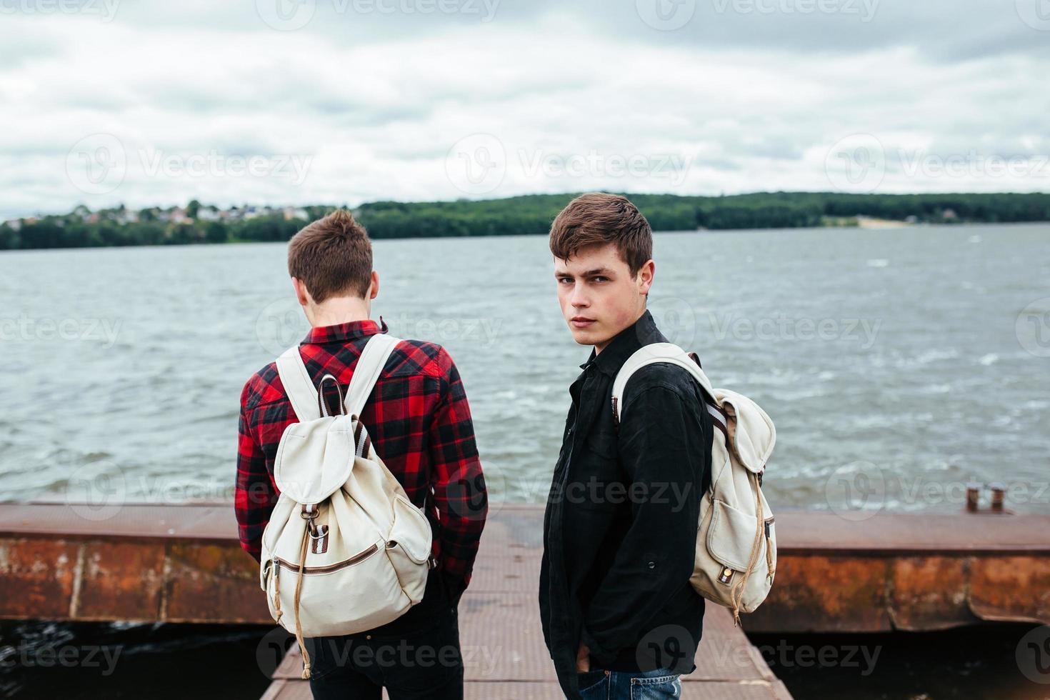 two young guys stand on the pier photo