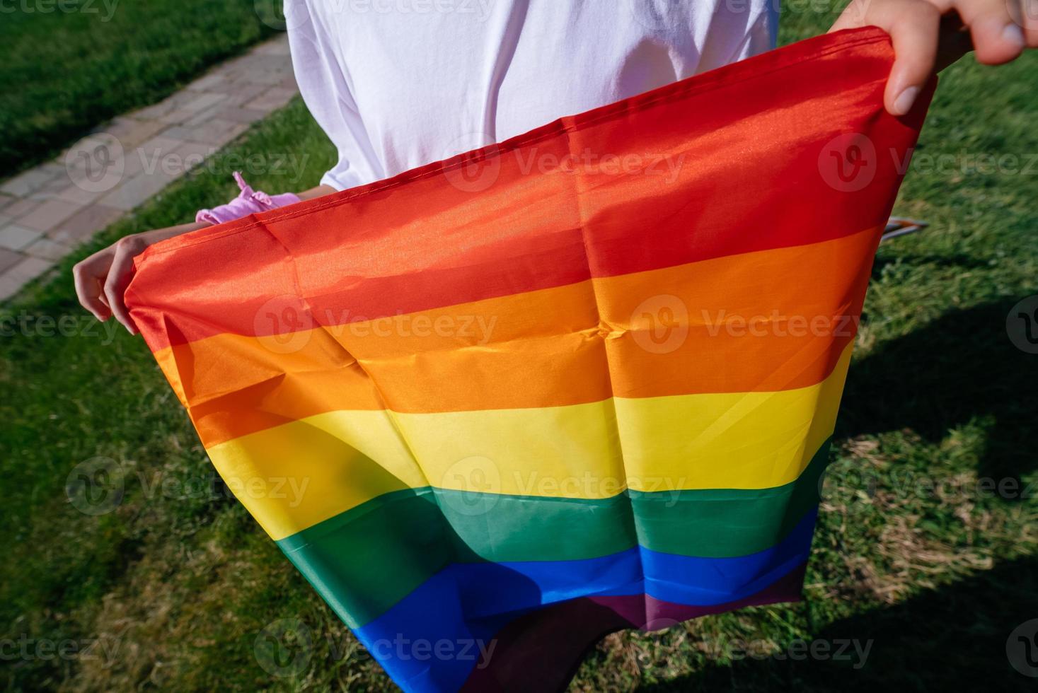 Cropped photo of young woman with LGBT pride flag.