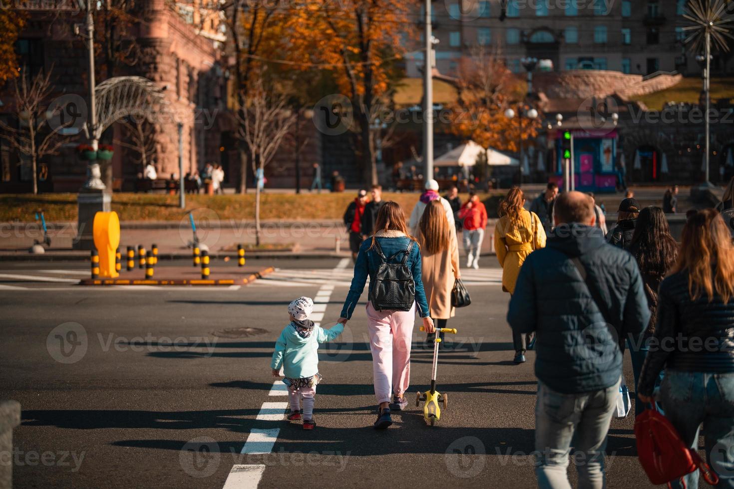 Lots of people crossing the street at the traffic lights. photo