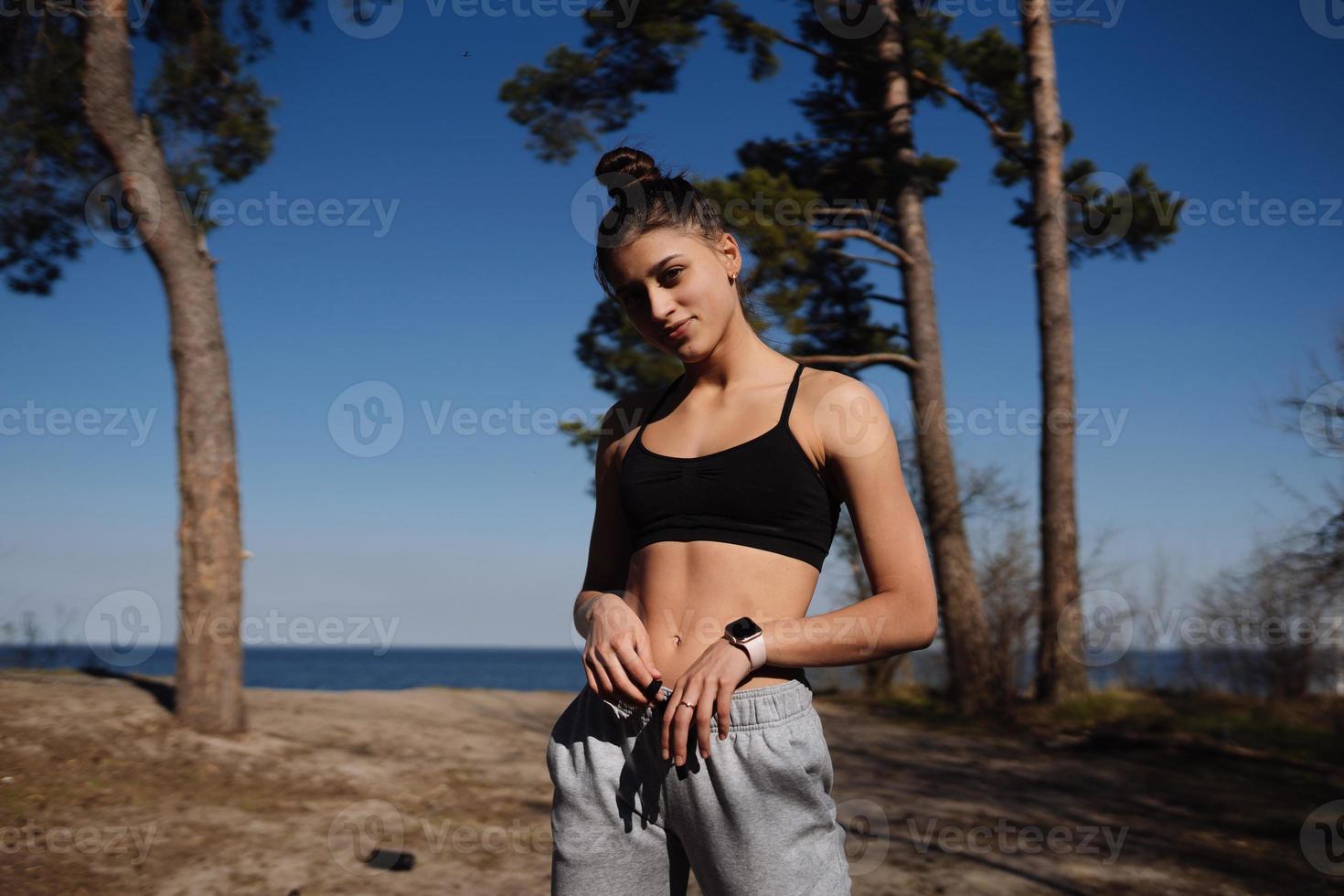 Fitness young woman walks in the park and posing for the camera photo