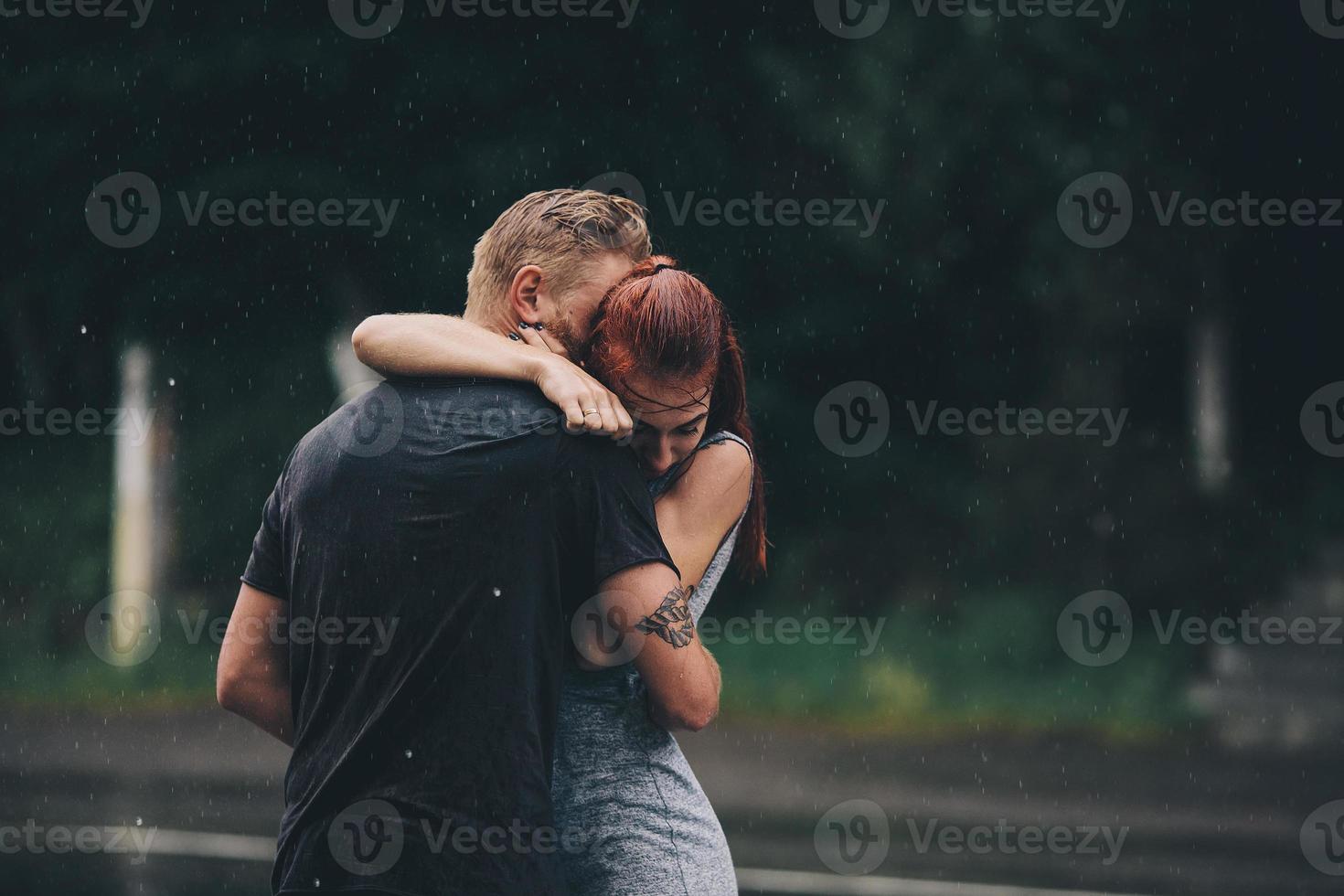 beautiful couple hugging in the rain photo