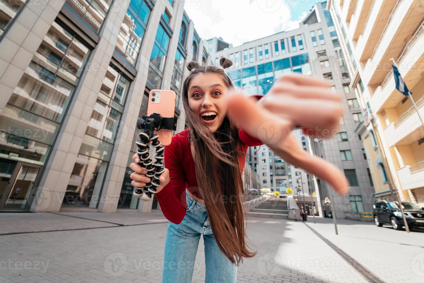 Beautiful female blogger looking at the camera on the street. photo