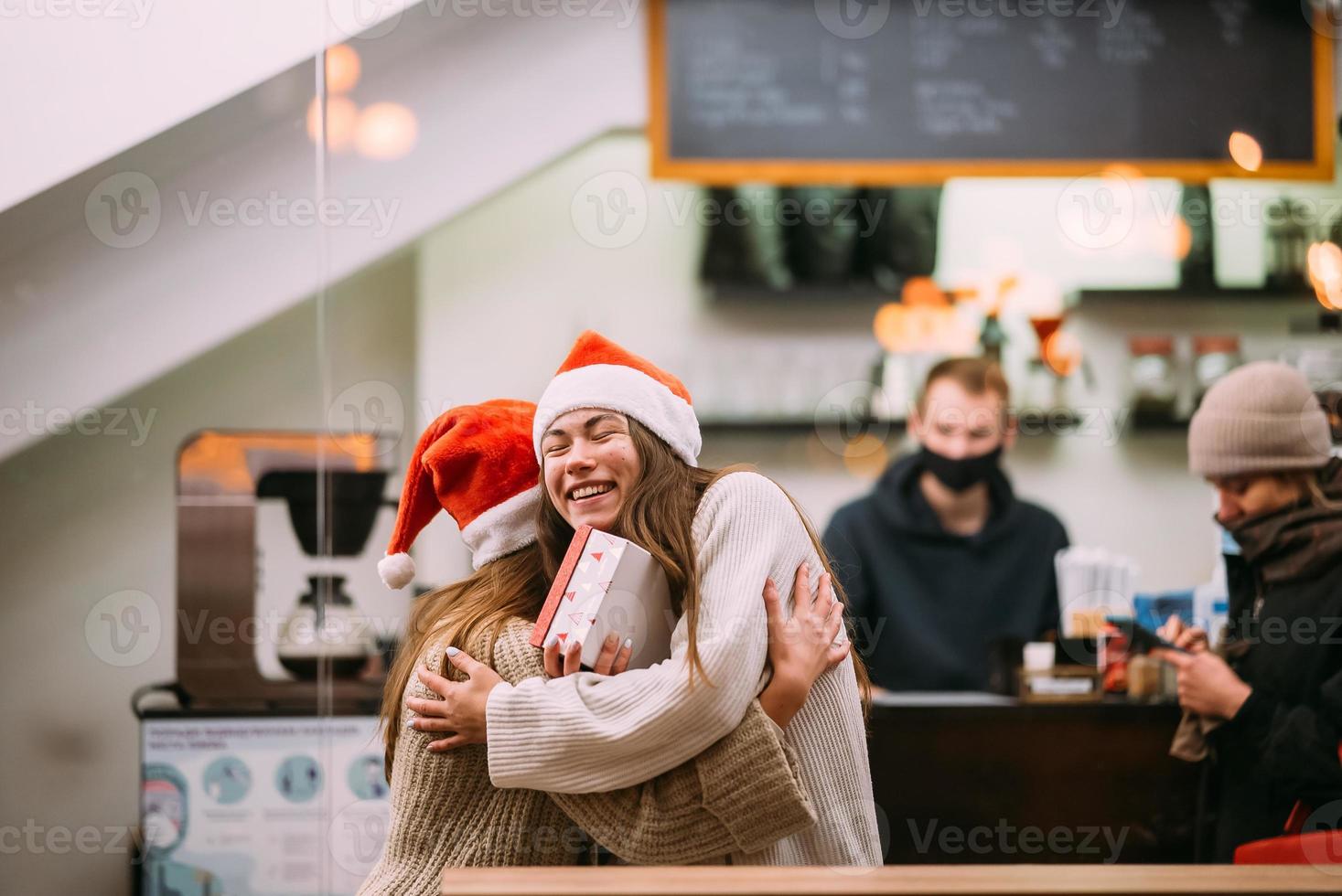 The girl gives a gift to her female friend in caffe photo