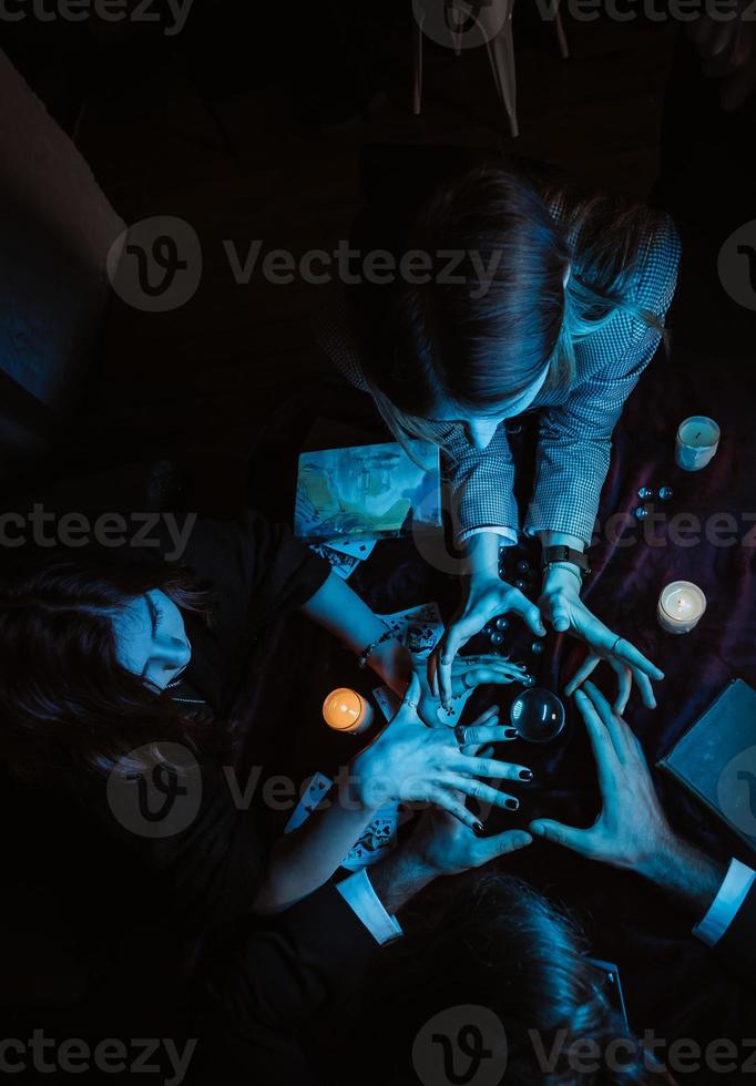 Group of people and woman fortune teller with crystal ball photo