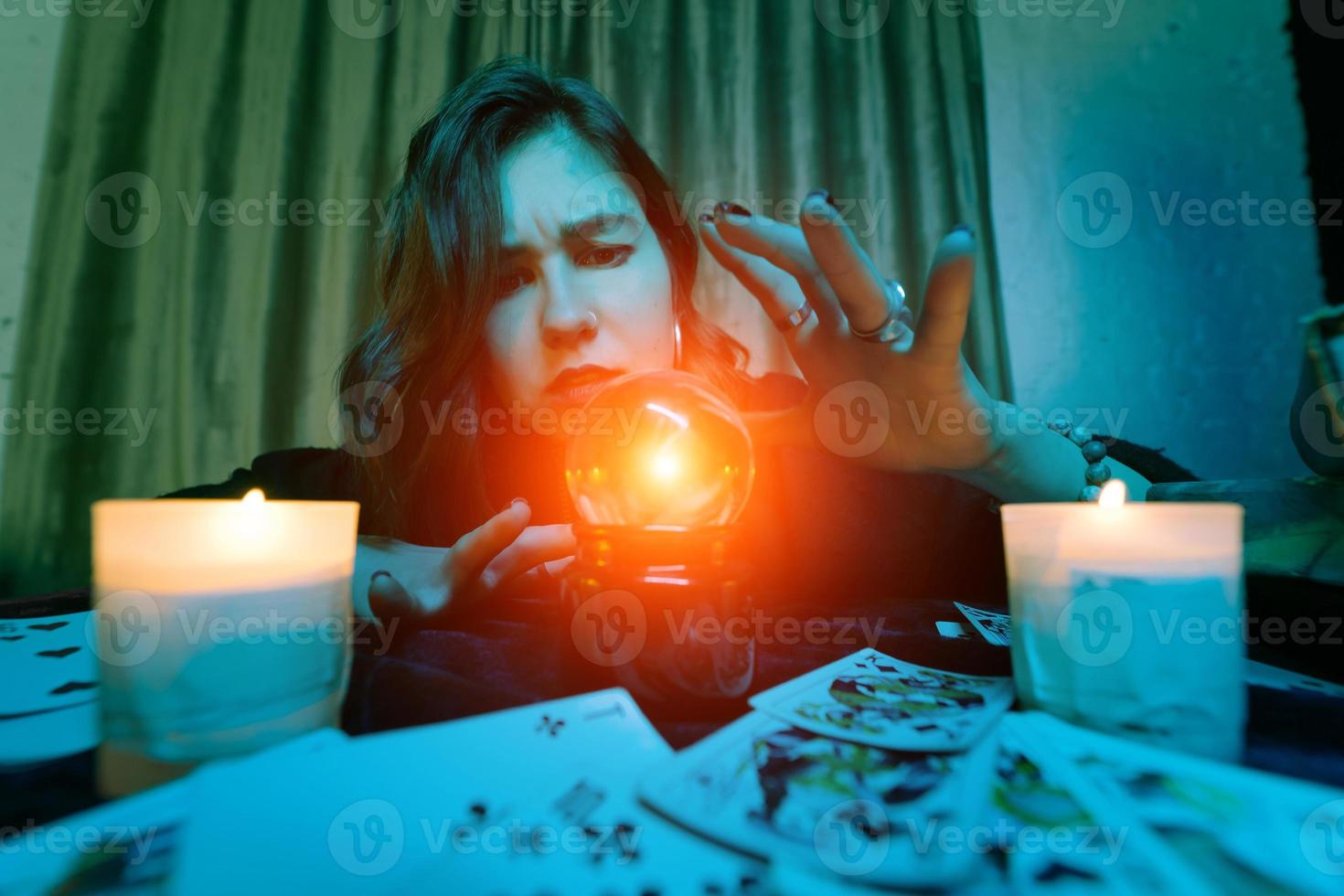 mujer adivina adivina el destino de la noche en la mesa con velas foto