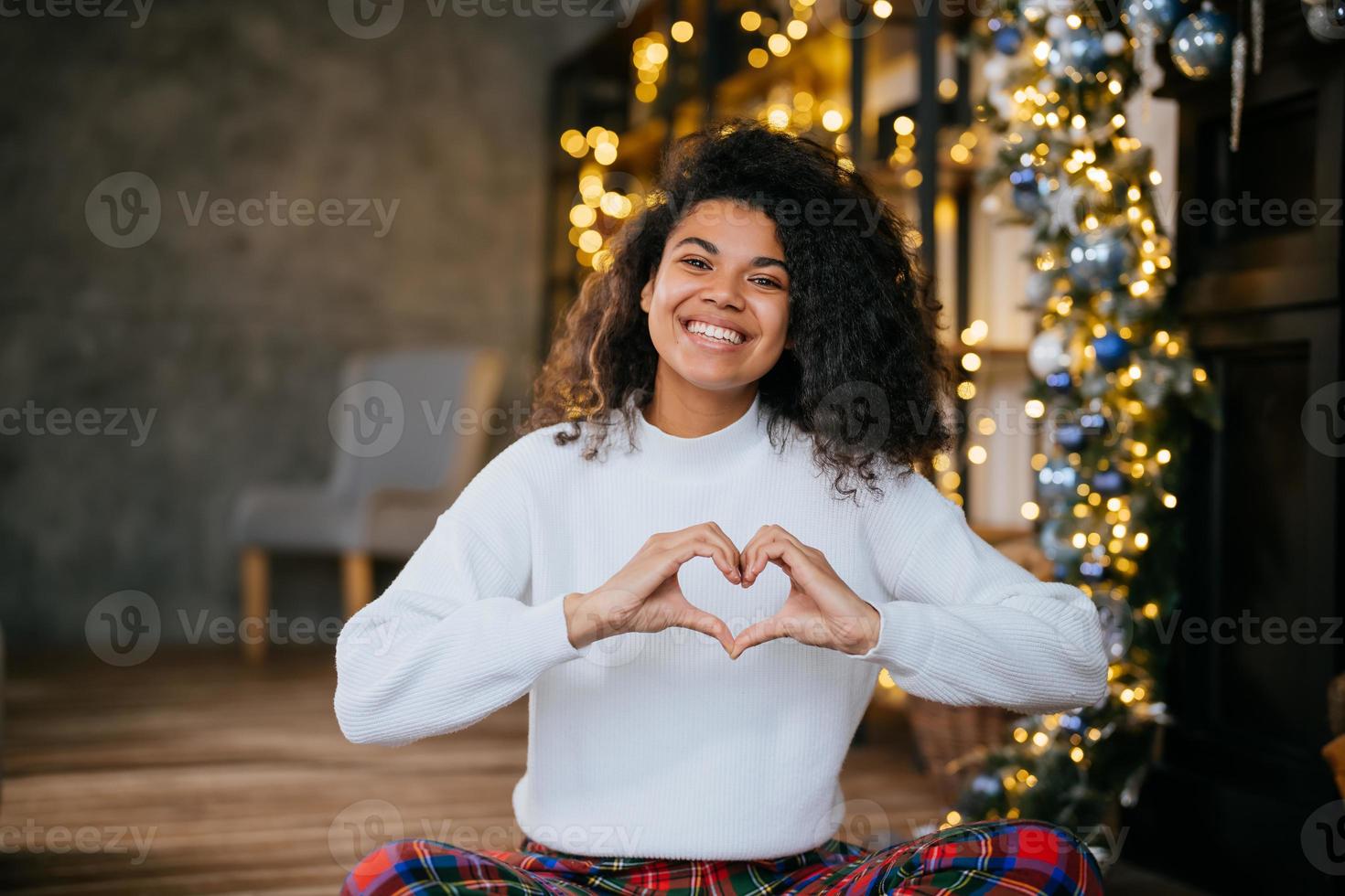 hermosa joven afroamericana haciendo forma de corazón con sus manos foto