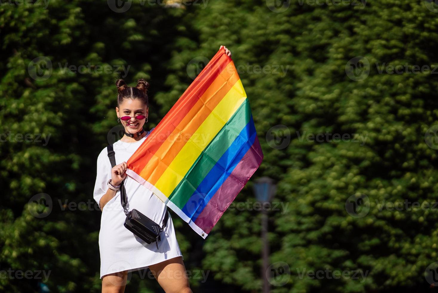 Young woman holding an LGBT pride flag in her hands. photo