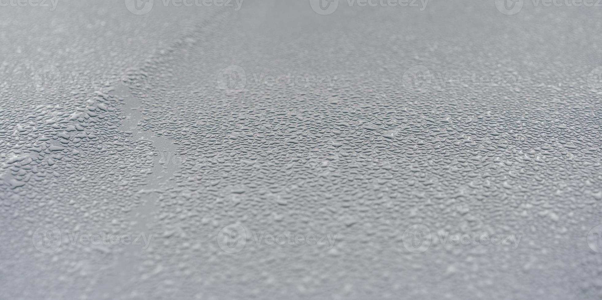 Raindrops on the hood of the car. Close-up. photo
