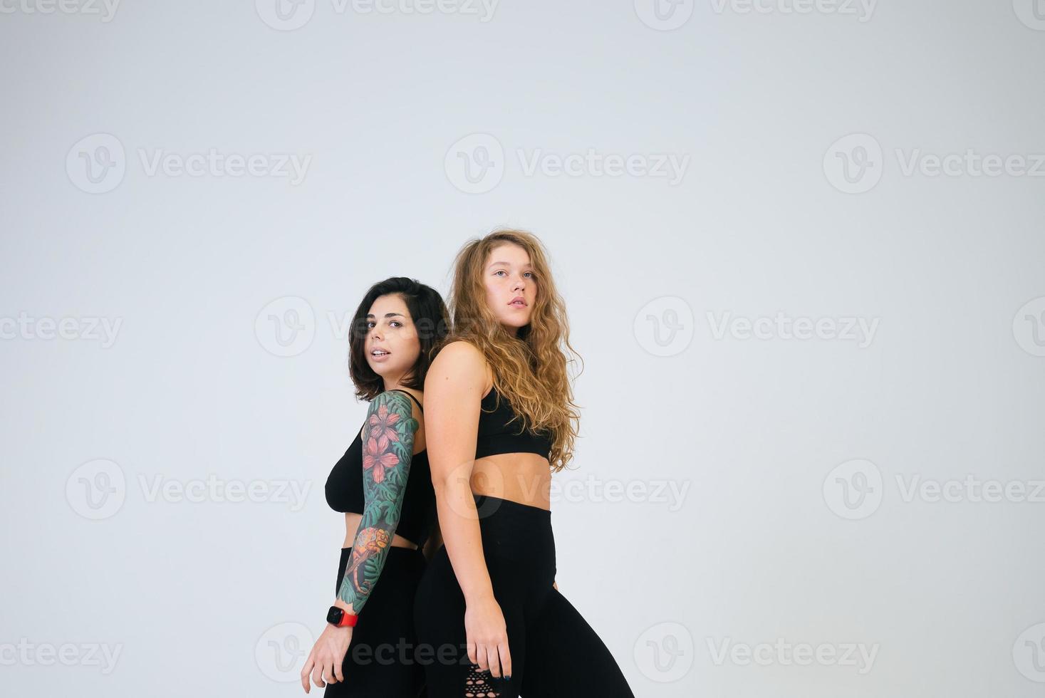 dos mujeres jóvenes posando sobre fondo blanco. foto