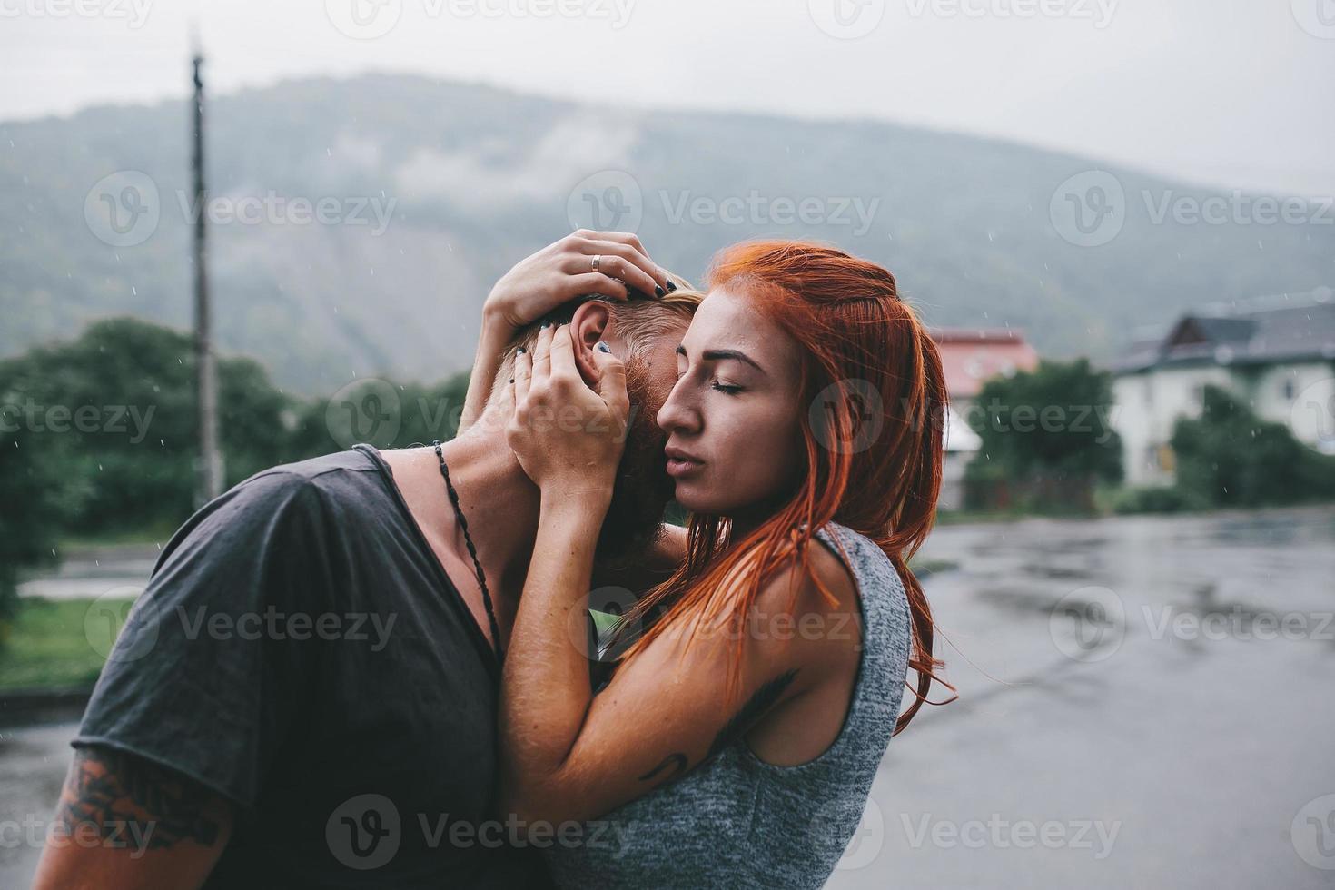 beautiful couple hugging in the rain photo