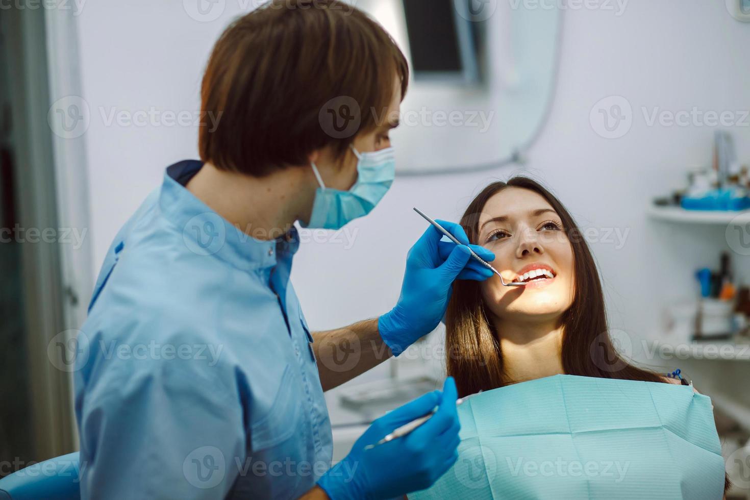 inspección de los dientes de la niña con la ayuda de un espejo foto