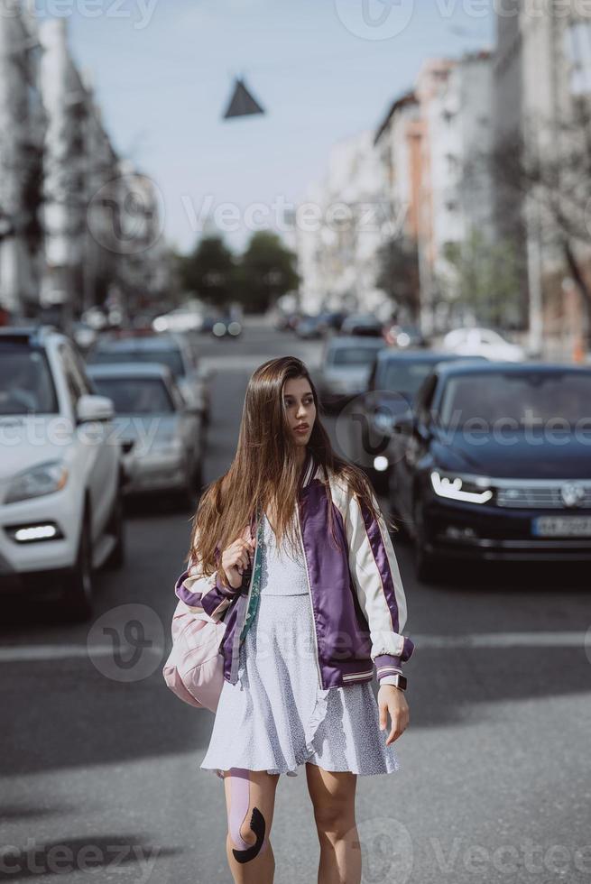 Young beautiful woman on the background of cars photo