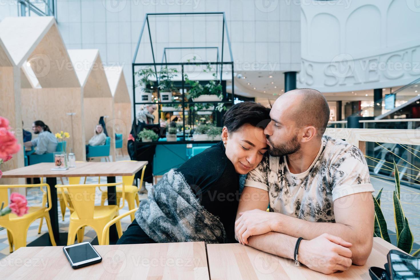 A man and a woman are sitting in a cafe photo