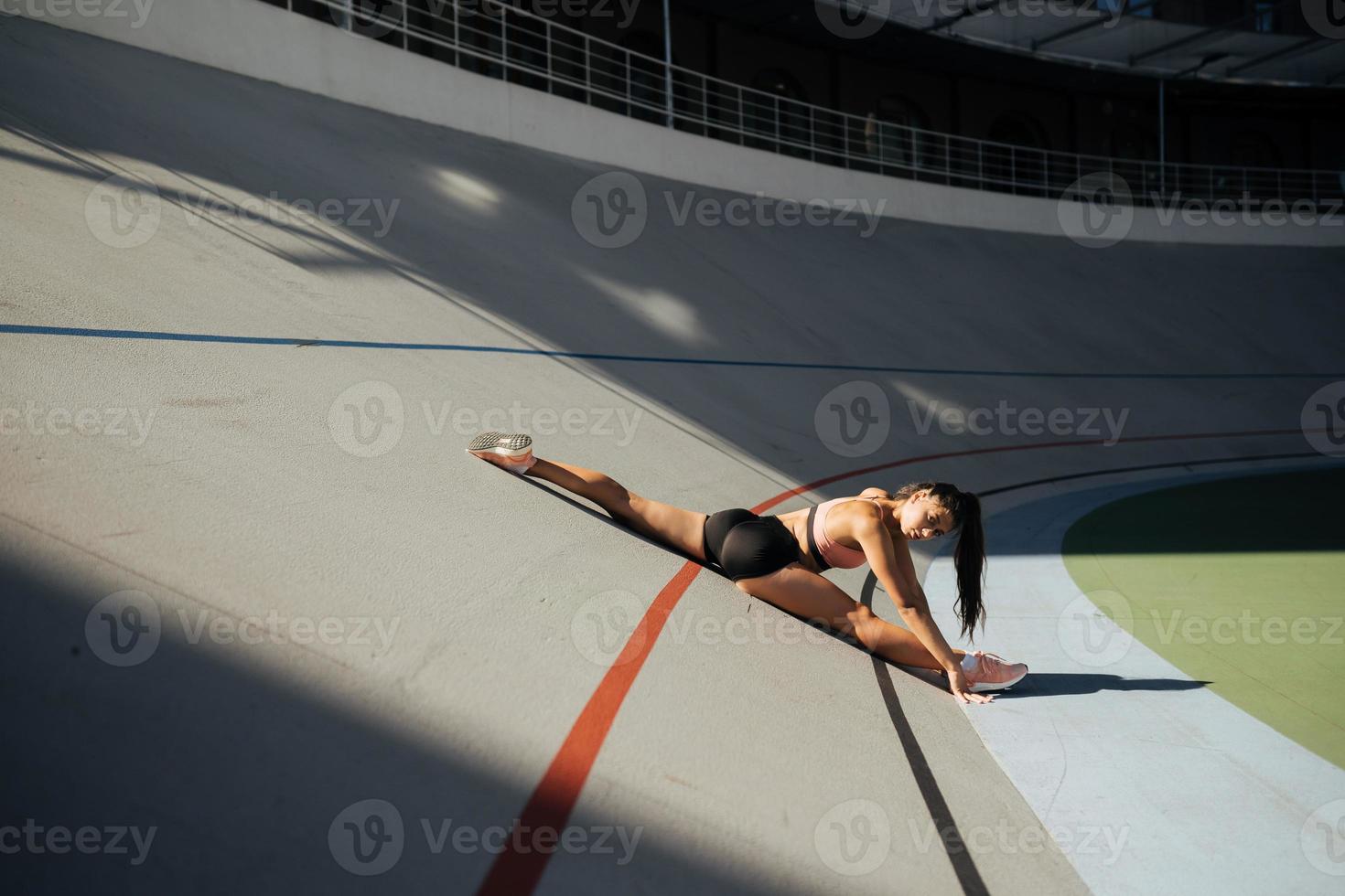 Young attractive female fitness woman performing a twine photo