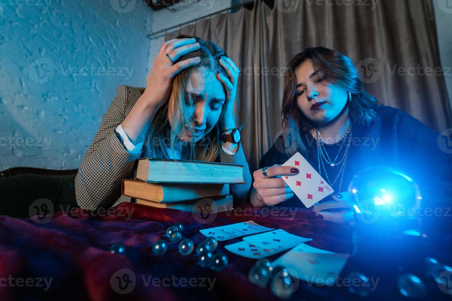 Fortune teller forecasting the future to woman with cards photo