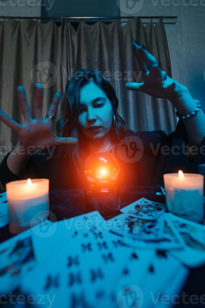 mujer adivina adivina el destino de la noche en la mesa con velas foto