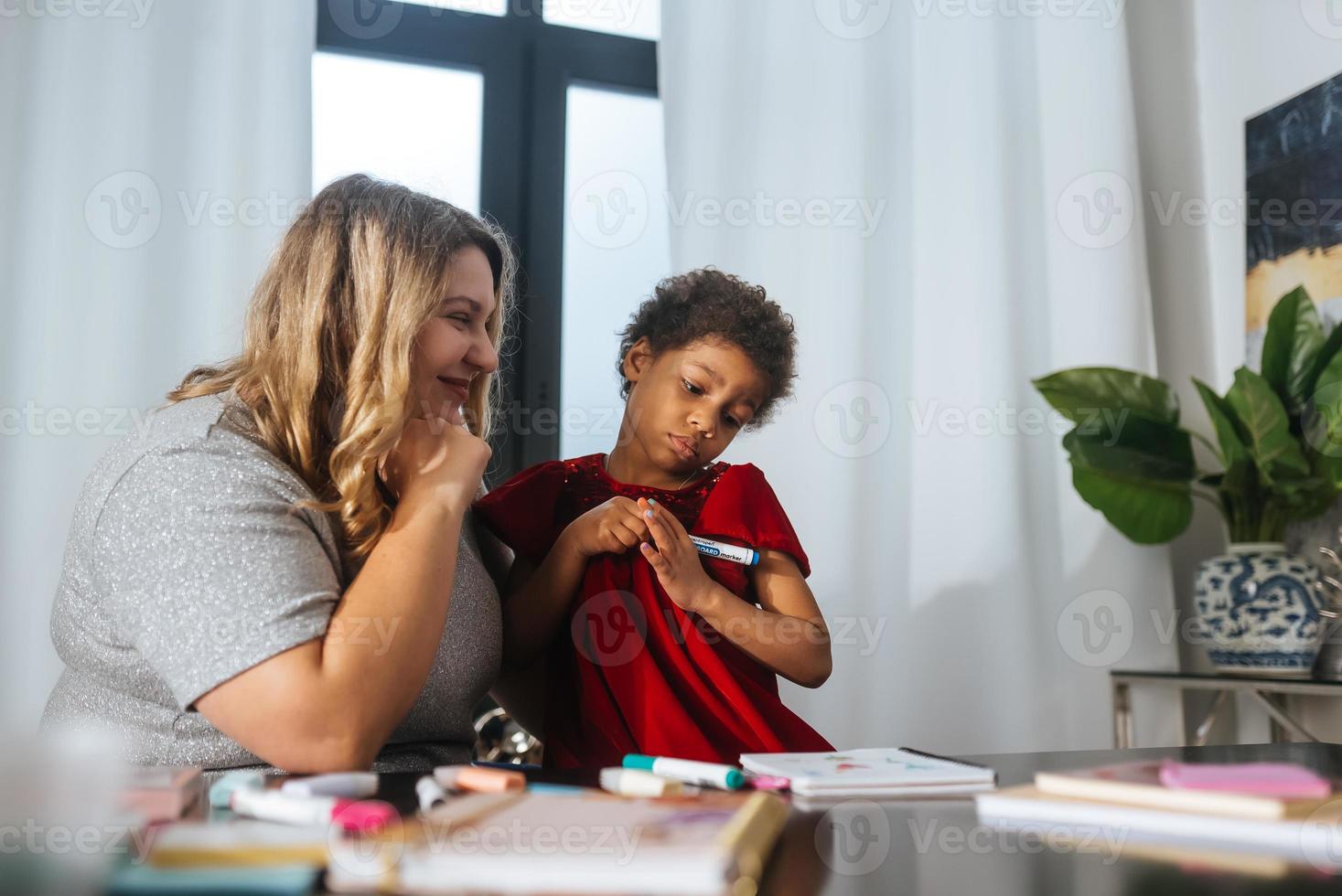 Mother and child daughter draws creatively at the table photo