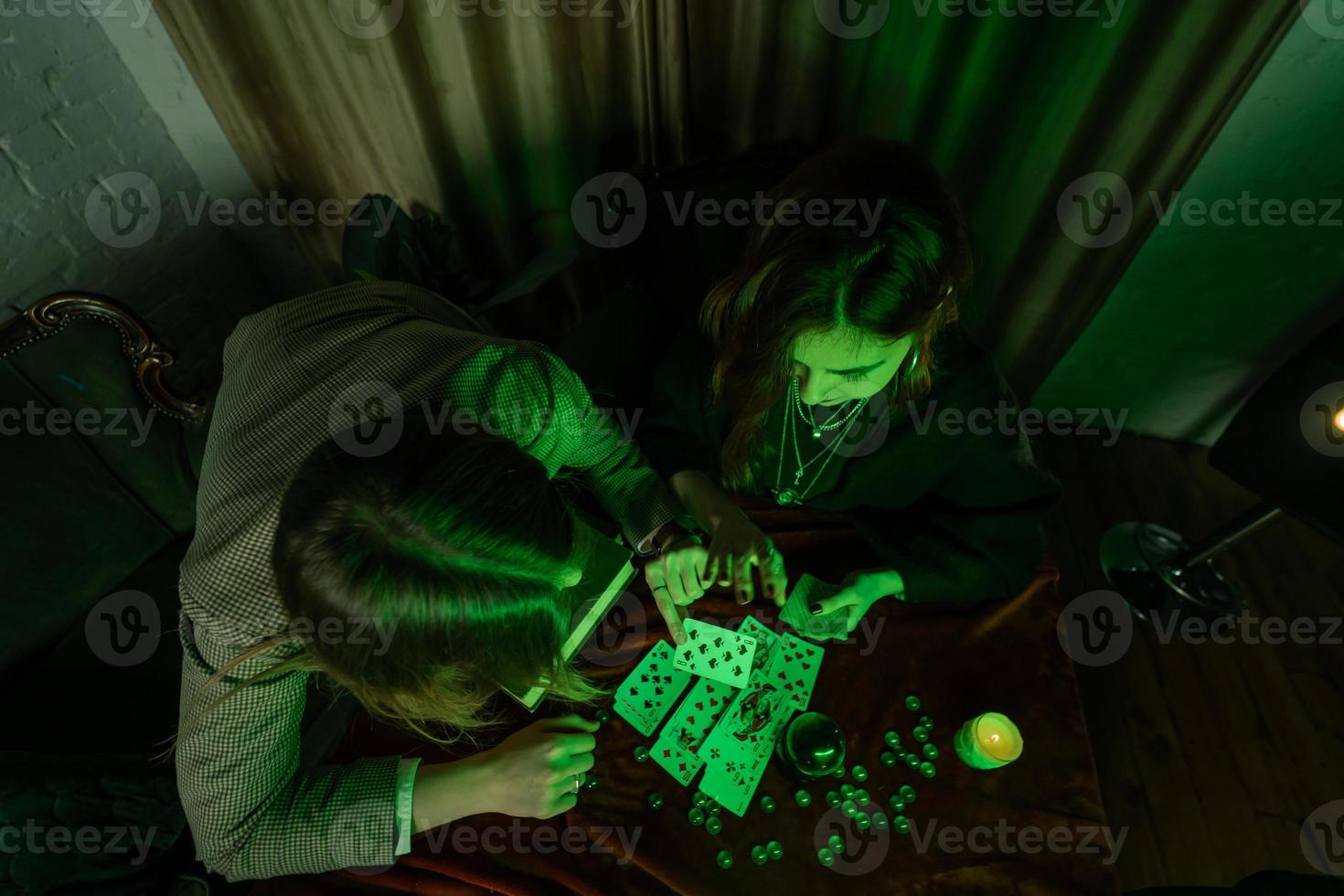 Fortune teller forecasting the future to woman with cards photo