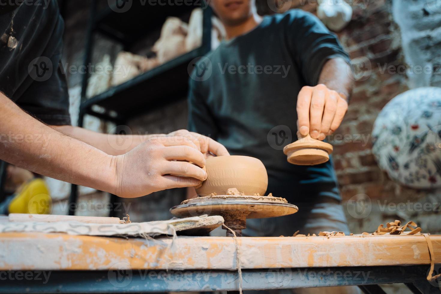 Making a handmade clay pot in the workshop. Pottery lesson, hobby. photo
