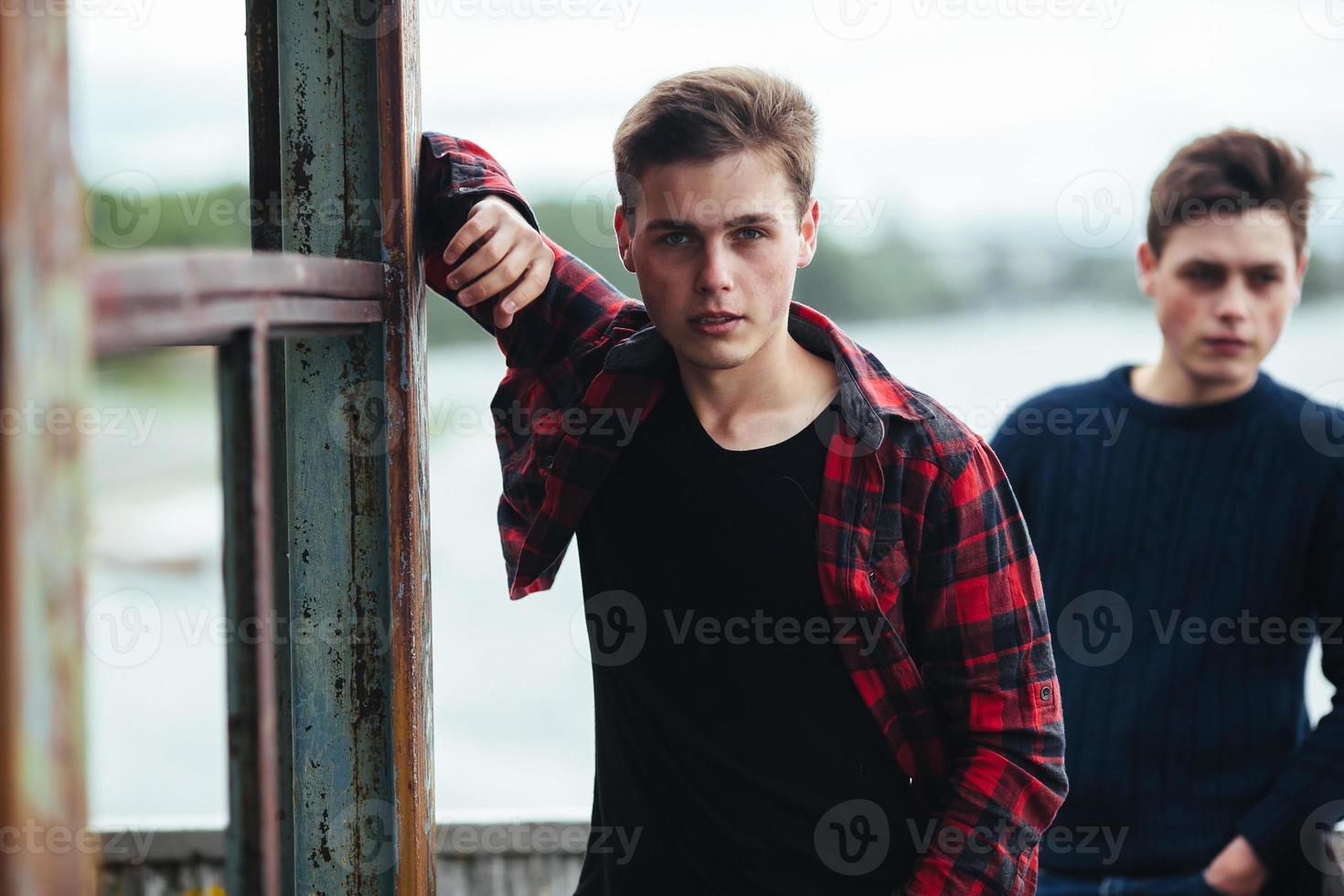 dos chicos están parados en un edificio abandonado en el lago foto