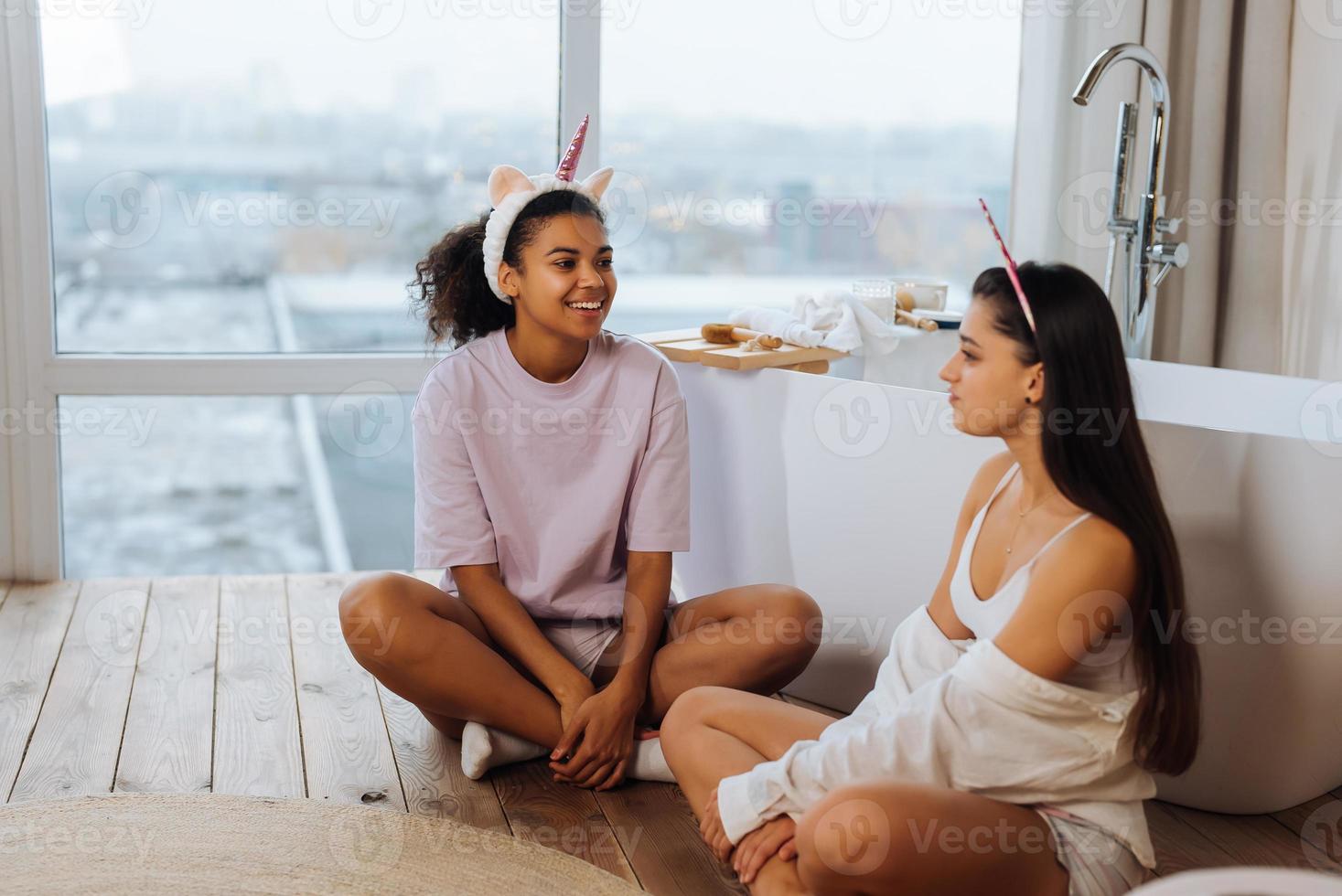 Two girls talking on the bathroom floor 11746289 Stock Photo at Vecteezy