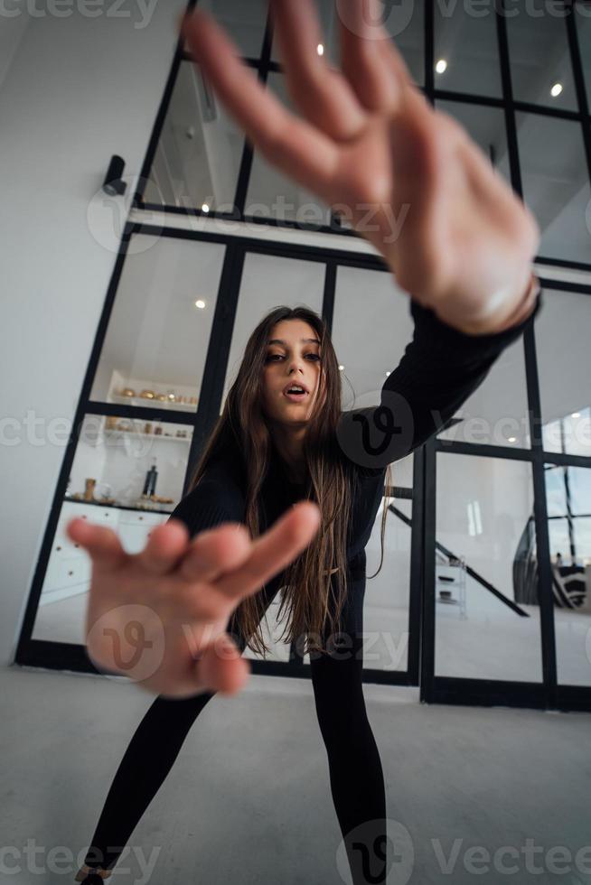 mujer en chándal se inclina hacia adelante y mueve los brazos hacia arriba y hacia abajo foto