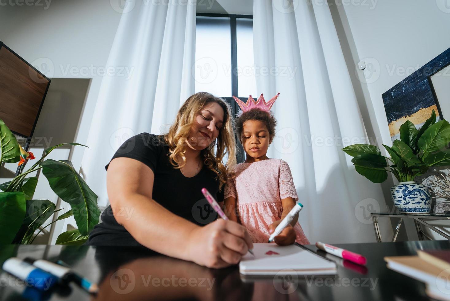 Mother and child daughter draws creatively at the table photo