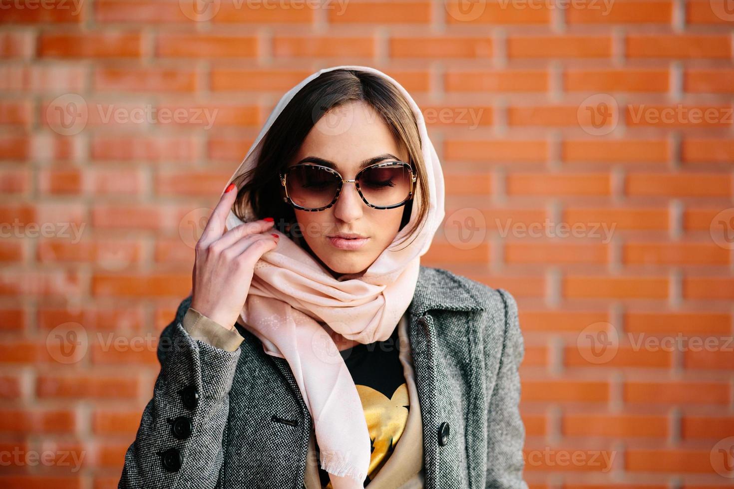 girl posing on a background of red brick wall photo