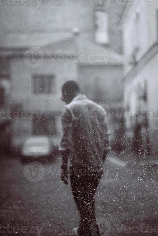 Portrait of carefree handsome young man is feeling free under the rain photo