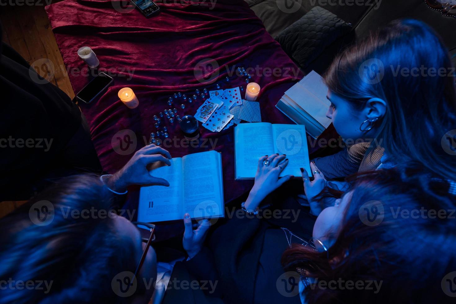 Two women and a guy are reading a mysterious books, close view photo