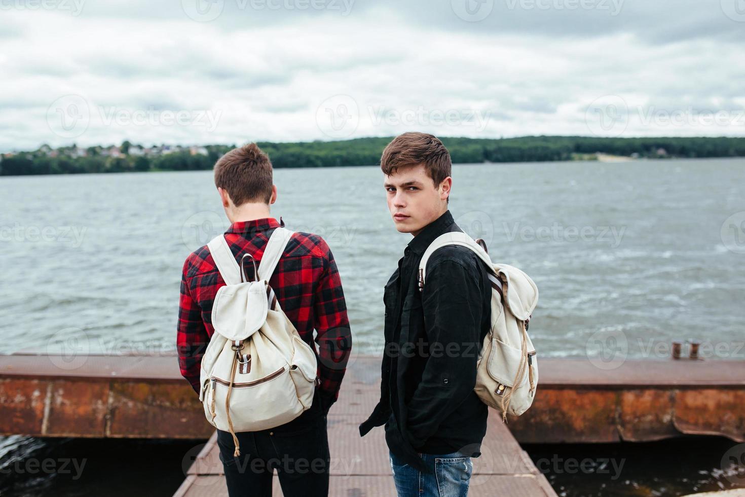 two young guys stand on the pier photo
