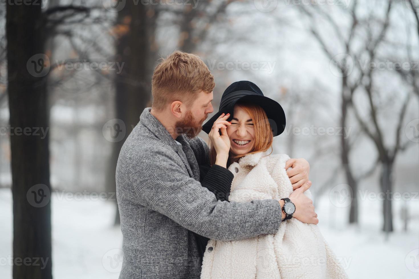 The guy and the girl are resting in the winter forest. photo