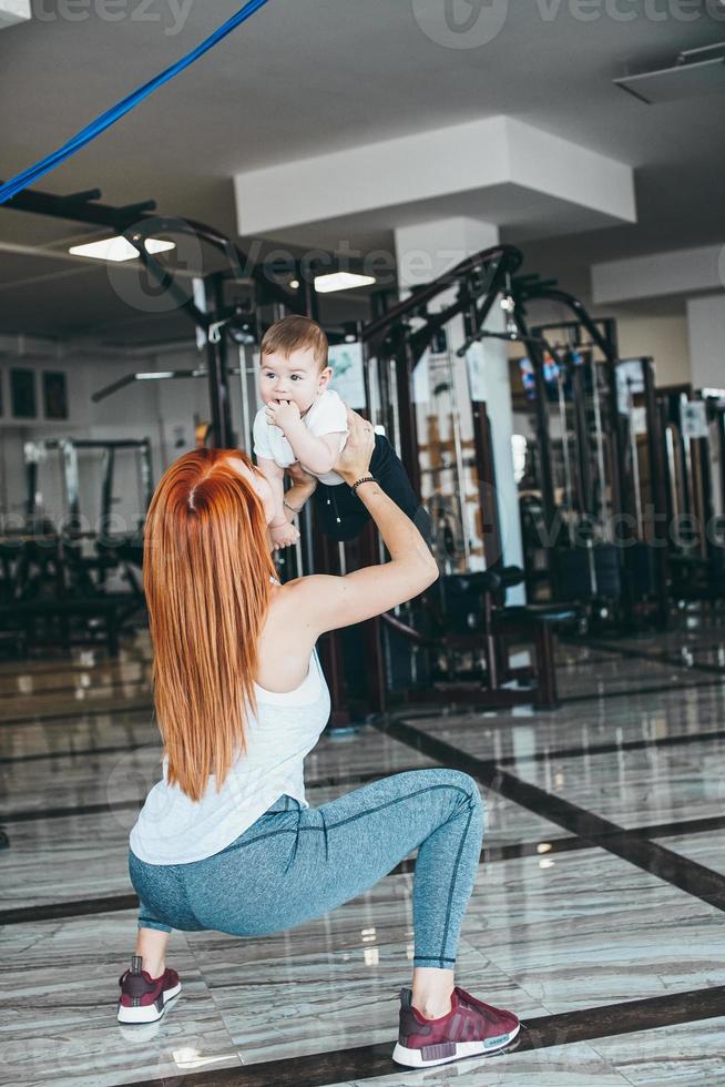 joven madre con su hijo pequeño en el gimnasio foto