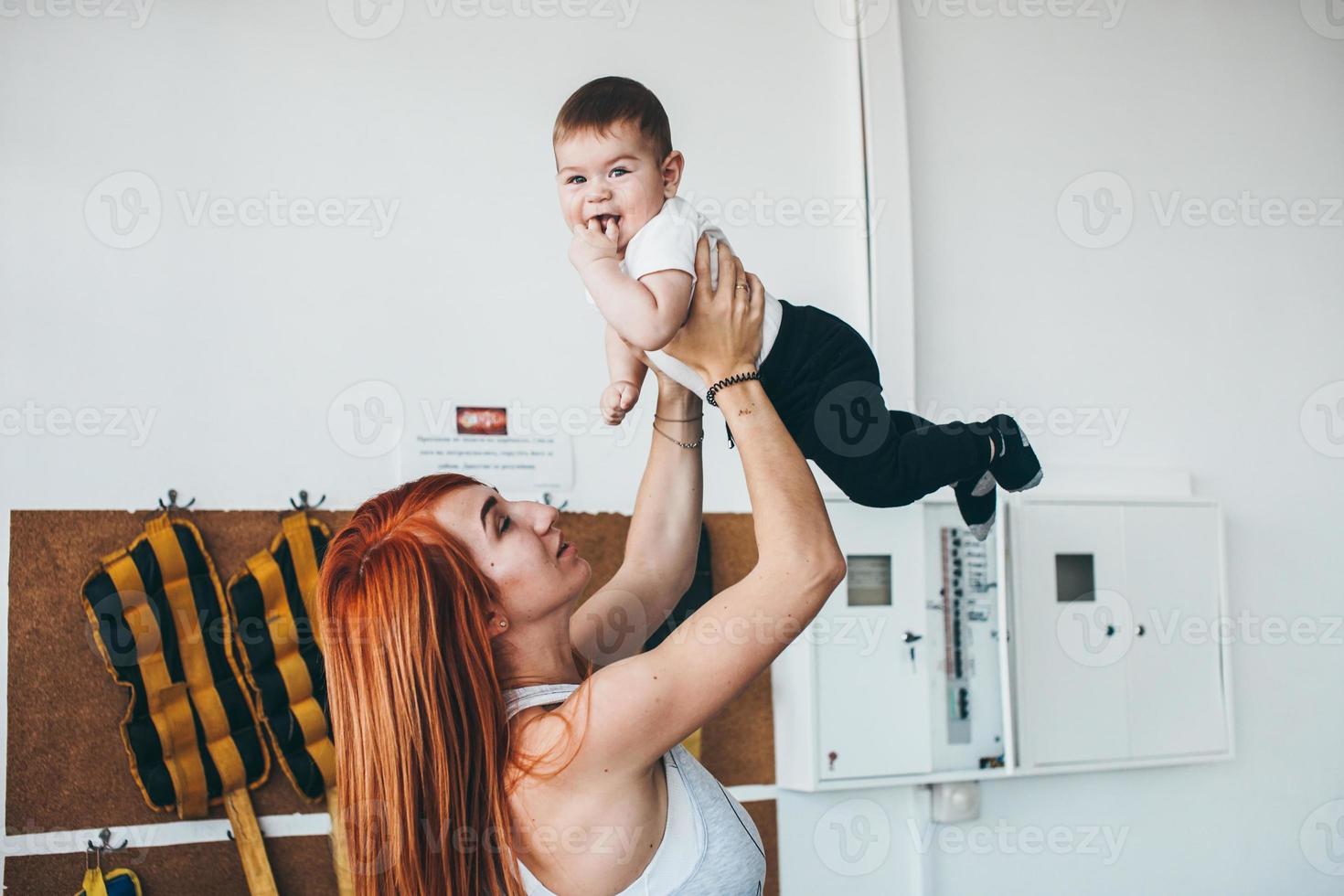 joven madre con su hijo pequeño en el gimnasio foto