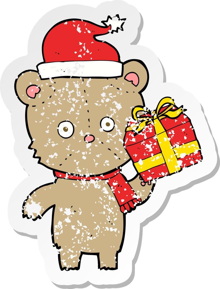 retro distressed sticker of a cartoon christmas teddy bear with present vector