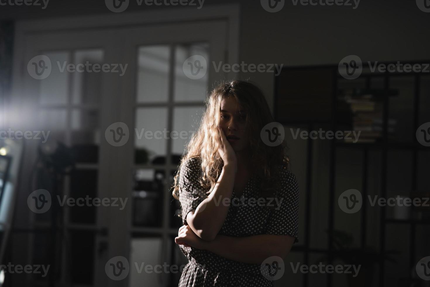 Serious beautiful young woman in dress posing for the camera. photo