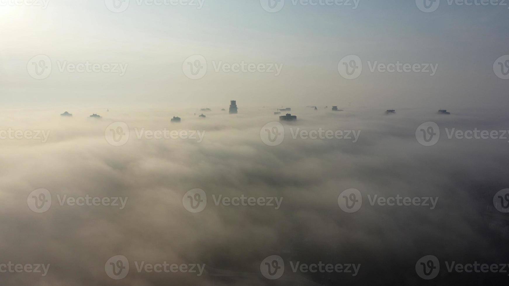 Aerial view of the city in the fog. Skyscrapers above the fog photo