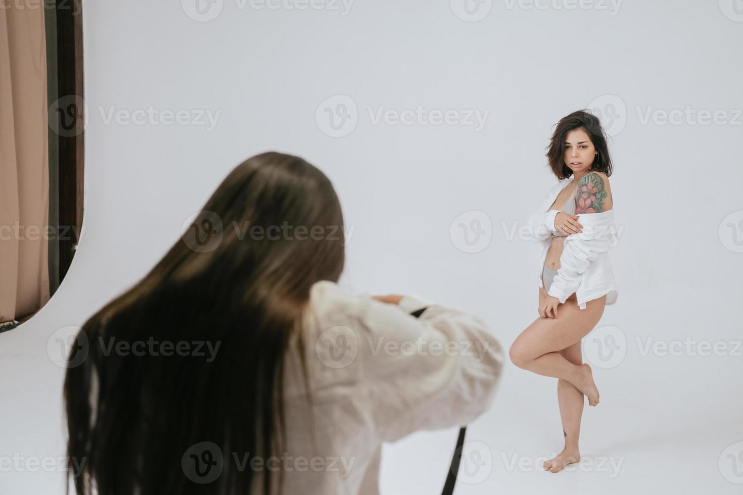 Professional male photographer taking pictures of woman model photo