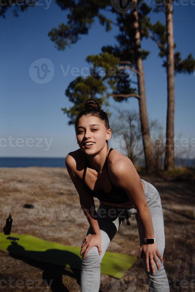 Fitness young woman walks in the park and posing for the camera photo