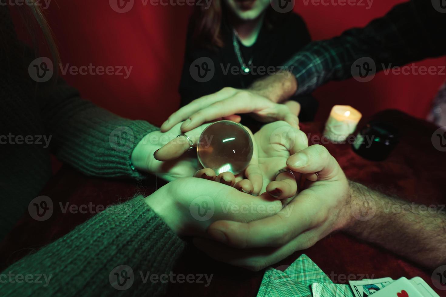 Group of people and woman fortune teller with crystal ball photo