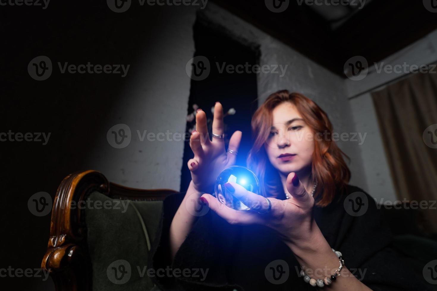 Woman in black suit holding crystal ball photo