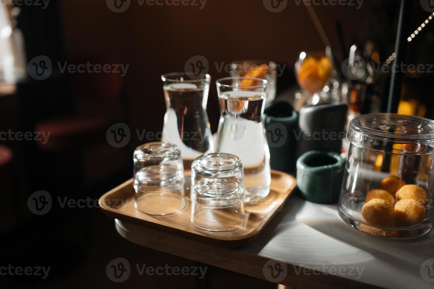 Four glass cups on the bar counter with serving accessories. photo