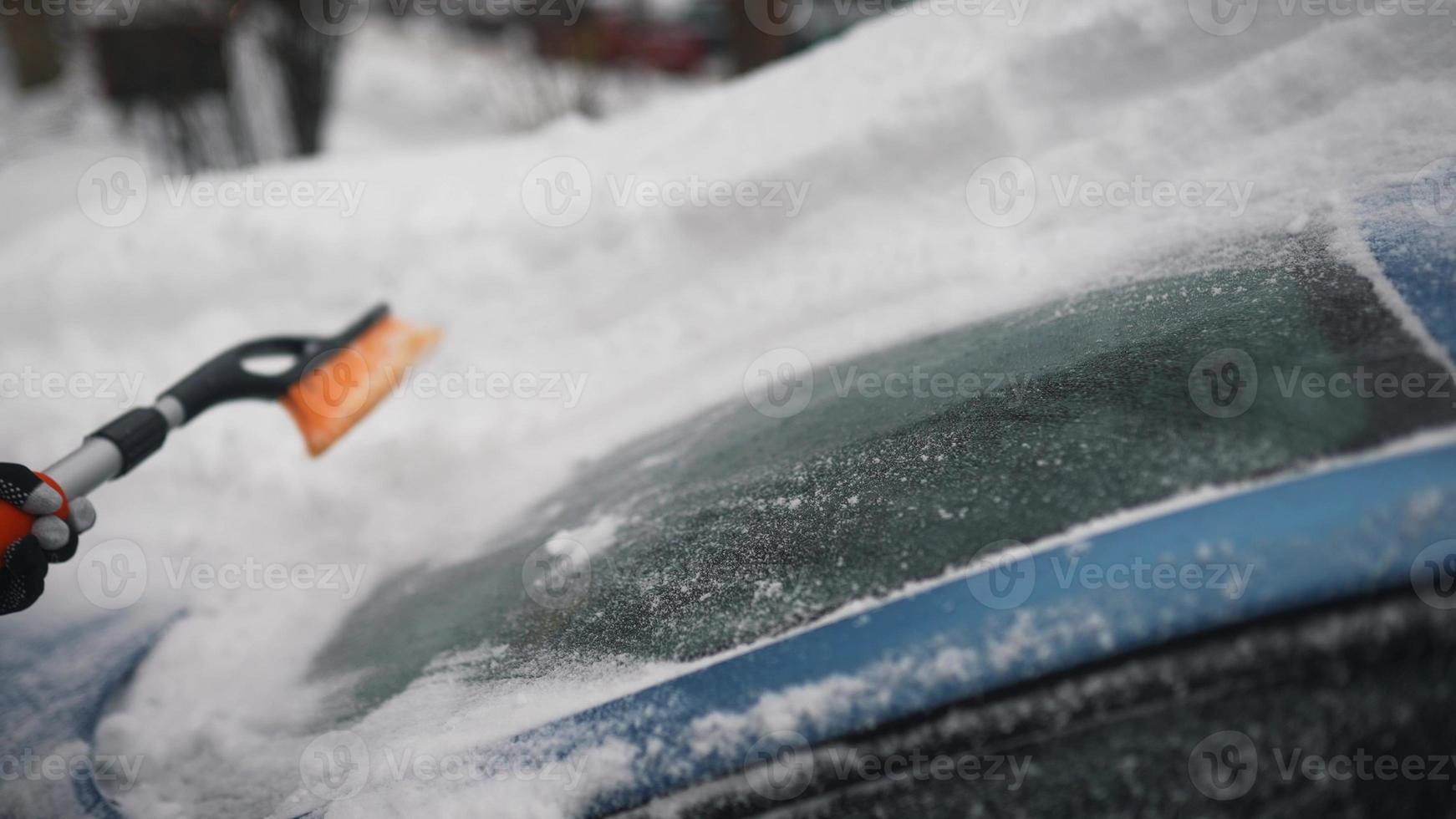 Woman removing snow from car photo