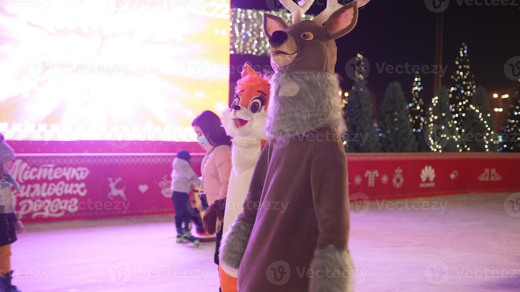 People enjoy ice skating in the street around Christmas tree in rink. photo