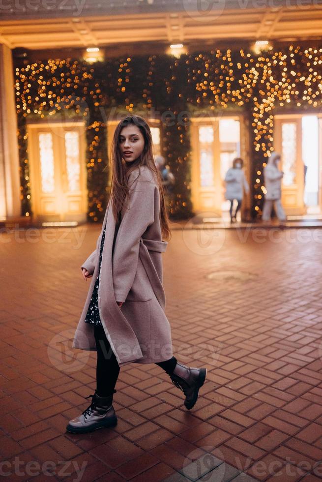 Girl on the background of the illuminated entrance to the building photo