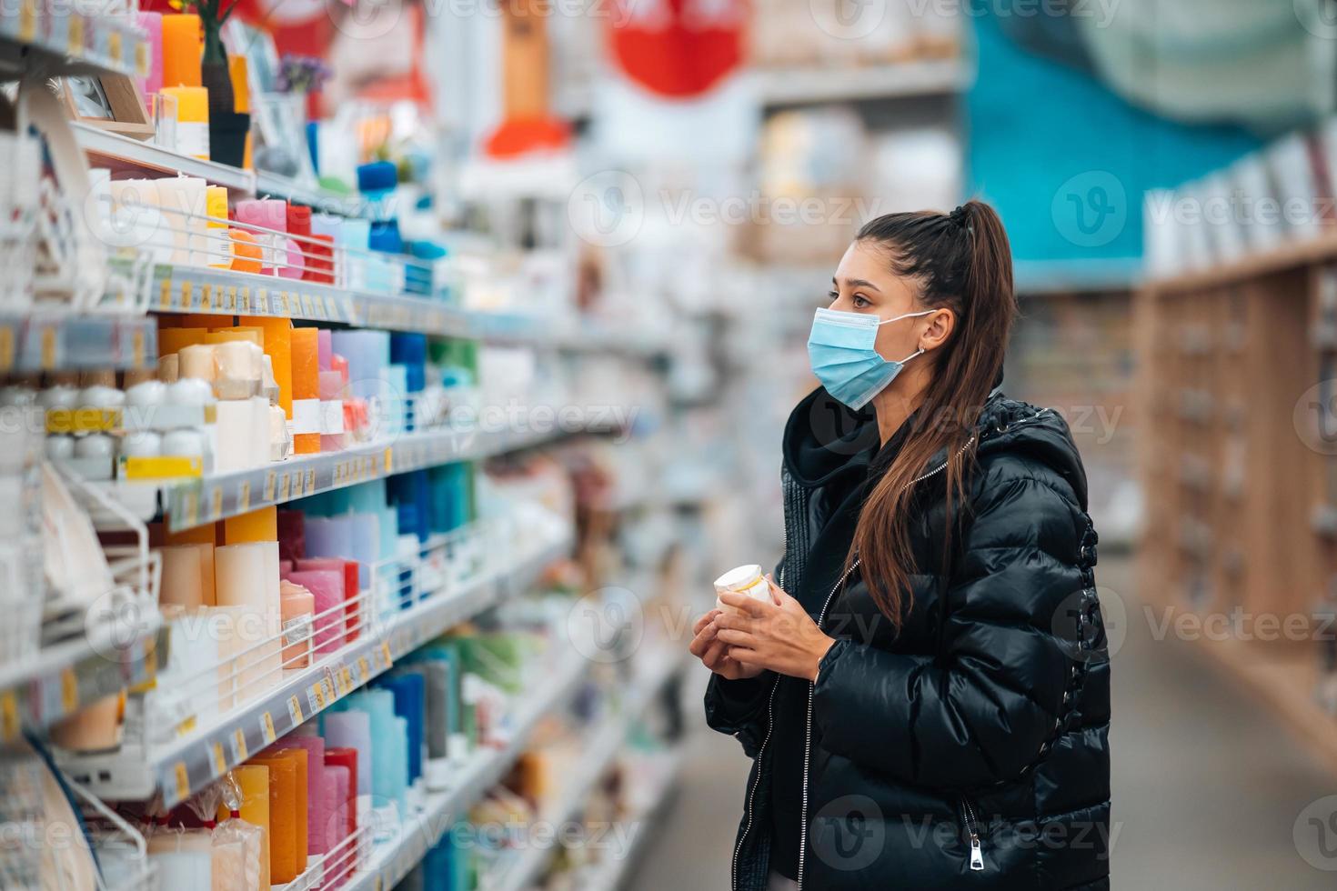 mujer con mascarilla comprando durante la pandemia de virus. foto