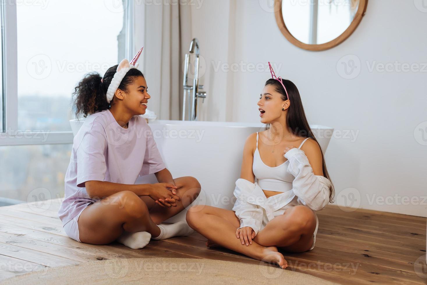 Two girls talking on the bathroom floor photo