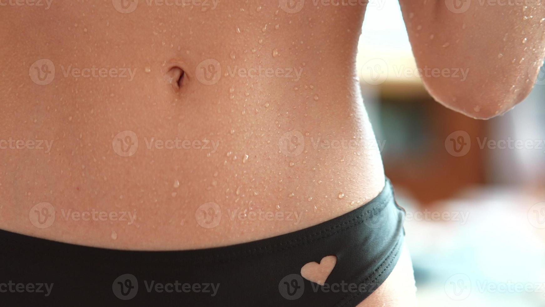 Close-up of erotic wet belly young woman photo