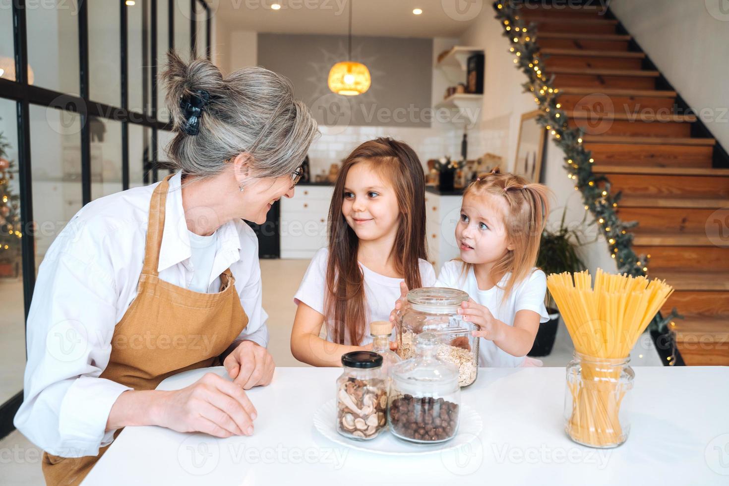 Grandmother and granddaughter are cooking on kitchen. photo